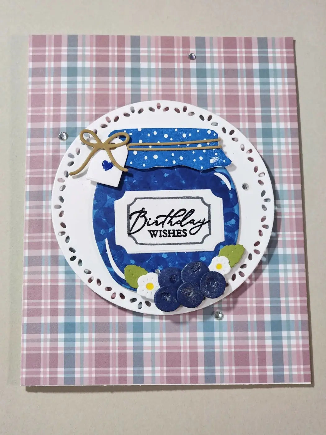 A blue textured glass jar greeting card with birthday wishes label and gold ribbon bow for canadian made skincare gift