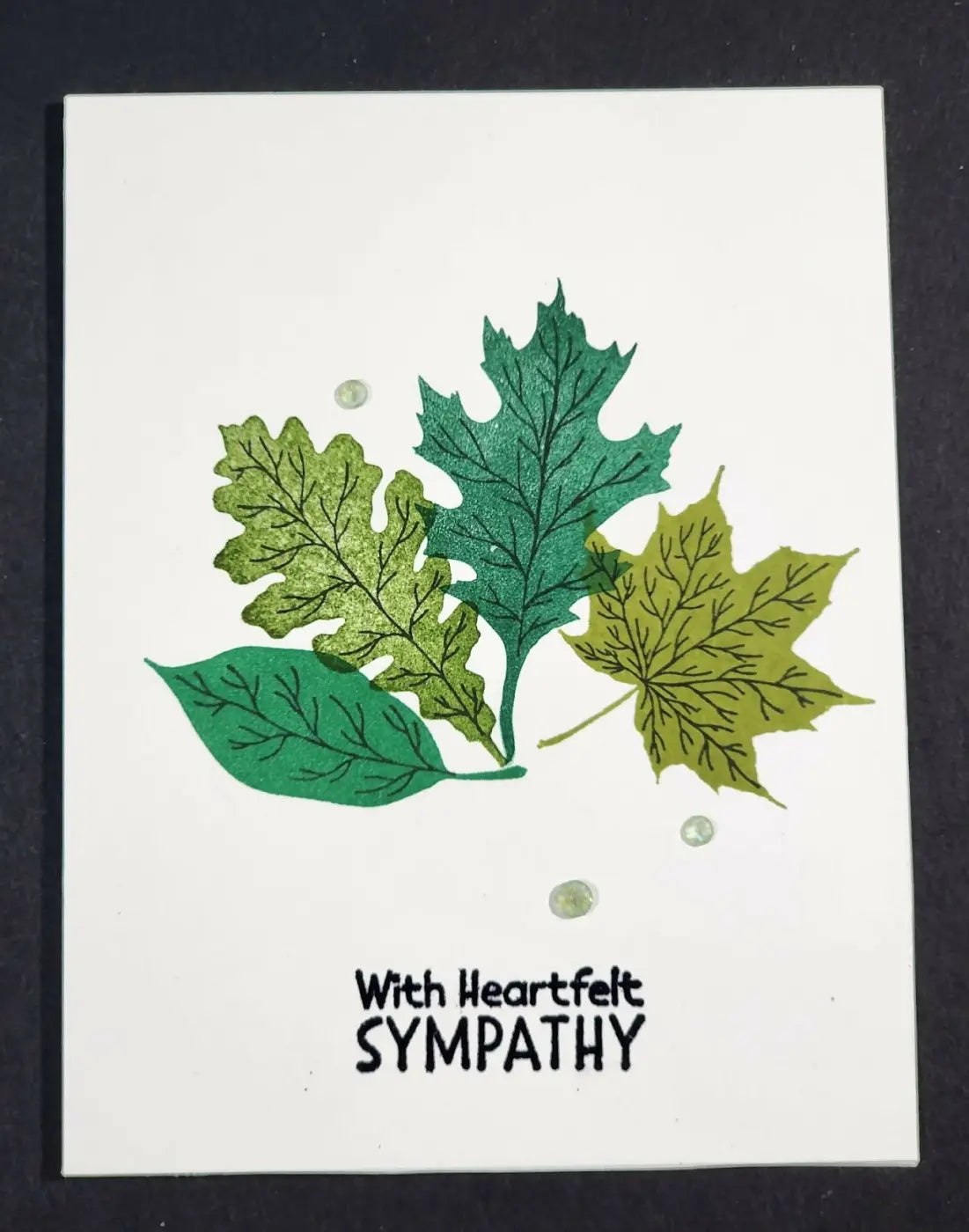 White sympathy greeting card with stamped green and yellow leaves and three clear rhinestones, ideal for natural skincare canada gifts