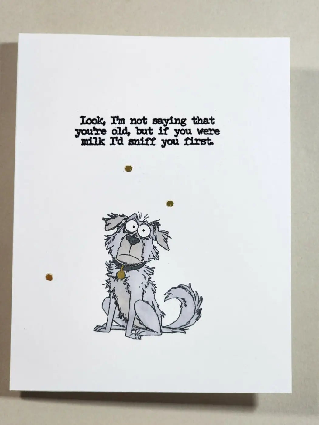 A white greeting card featuring a black and white dog illustration with humorous text for natural skincare canada gifts