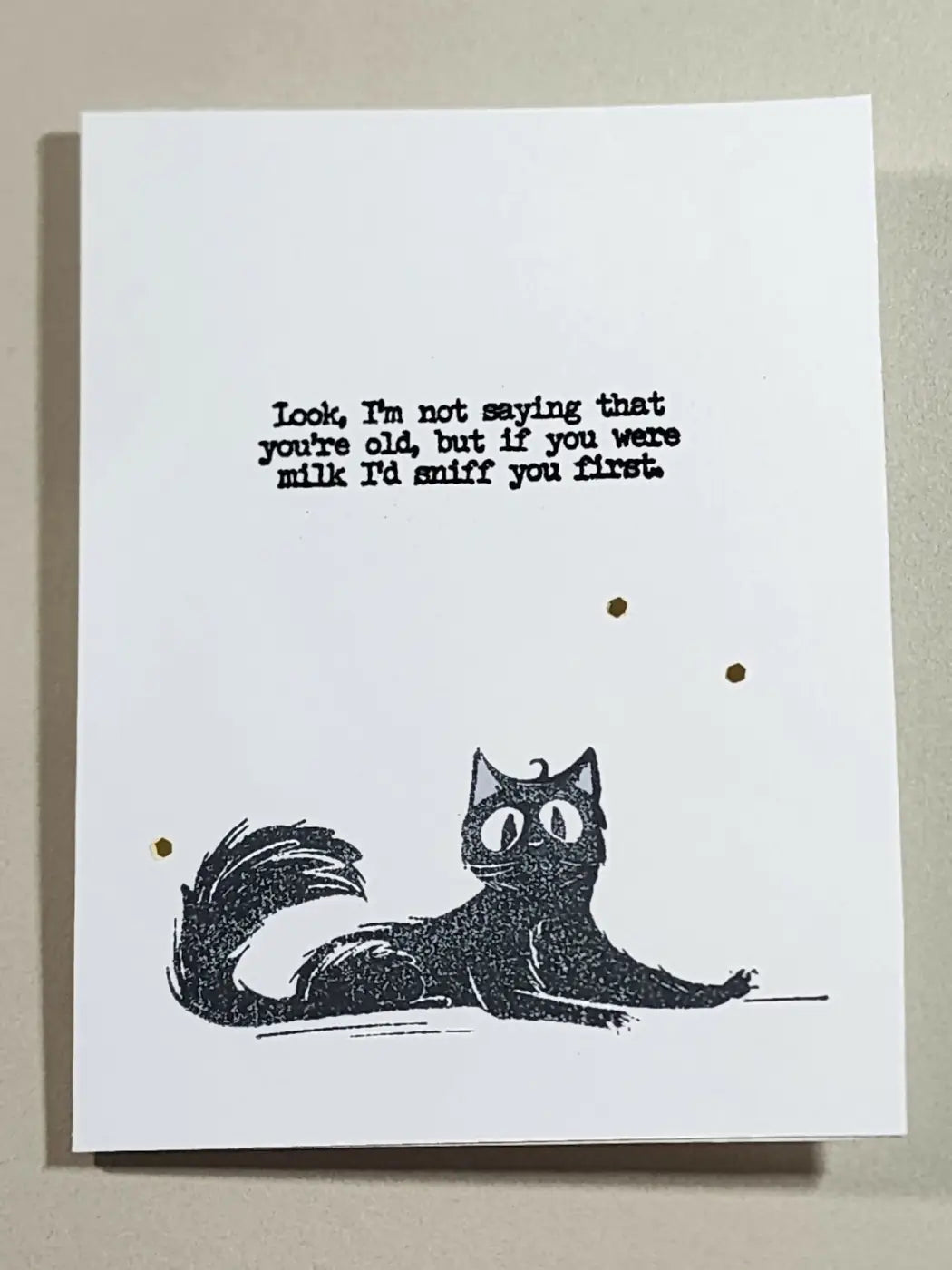 Black ink illustration of a cartoon cat with wide eyes on a white cardstock greeting card for natural skincare canada