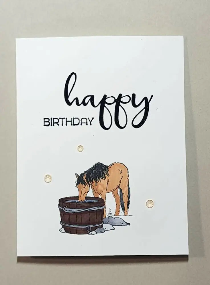 A charming white greeting card with a hand-drawn tan horse drinking from a wooden bucket, ideal for canadian made skincare gifts