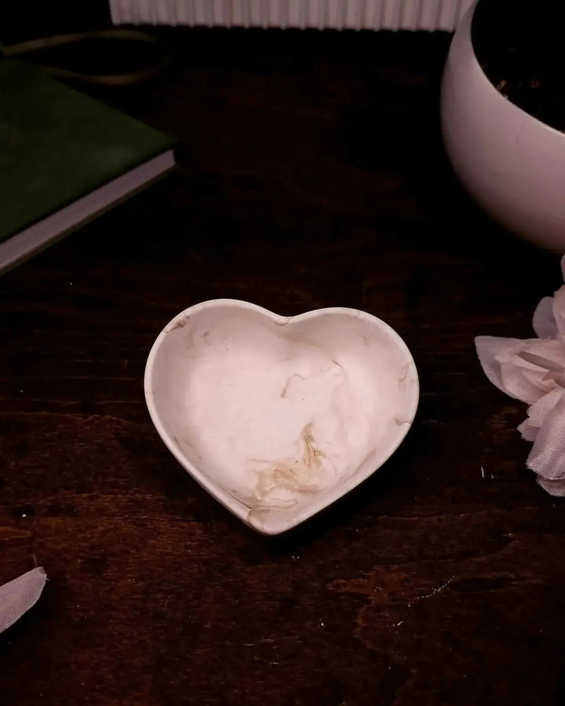 A white heart-shaped ceramic heart ring dish with a smooth slightly glossy finish for holding rings