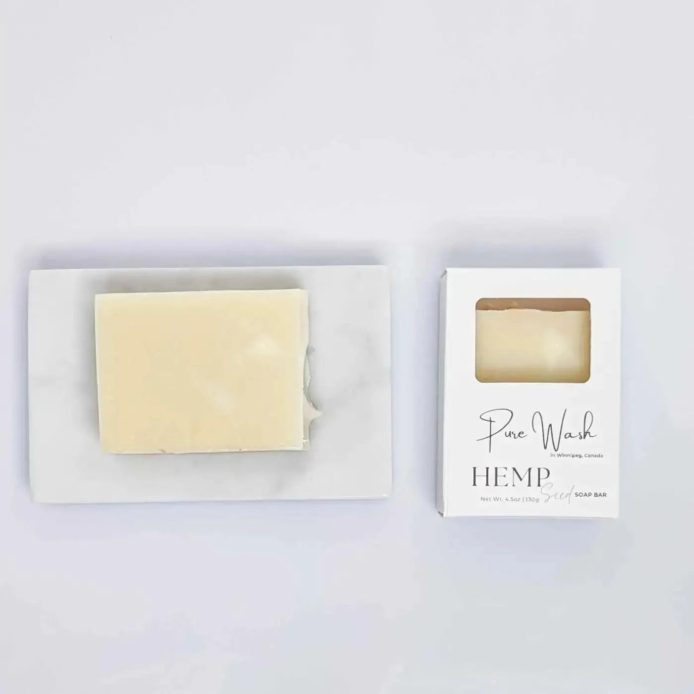 A pale yellow rectangular hemp seed soap bar from pure wash in a minimalist white box with elegant script branding