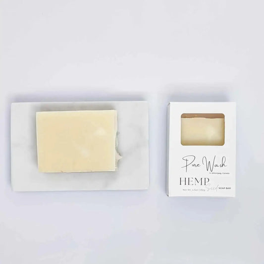 A pale yellow rectangular hemp seed soap bar from pure wash in a minimalist white box with elegant script branding