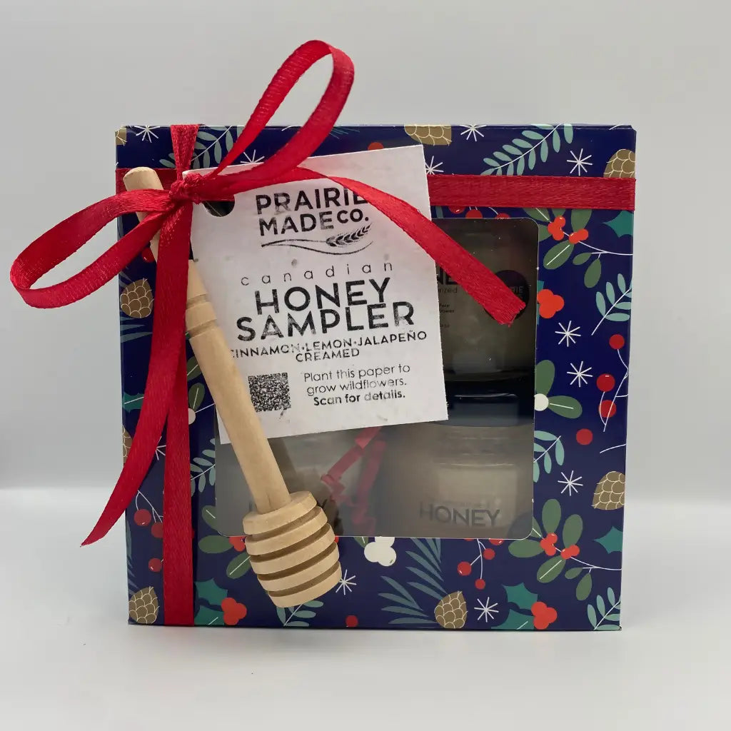 A wooden honey dipper with striped natural finish and rounded handle for holiday honey sampler featuring manitoba wildflower honey