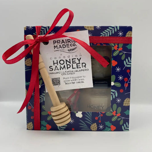 A wooden honey dipper with striped natural finish and rounded handle for holiday honey sampler featuring manitoba wildflower honey