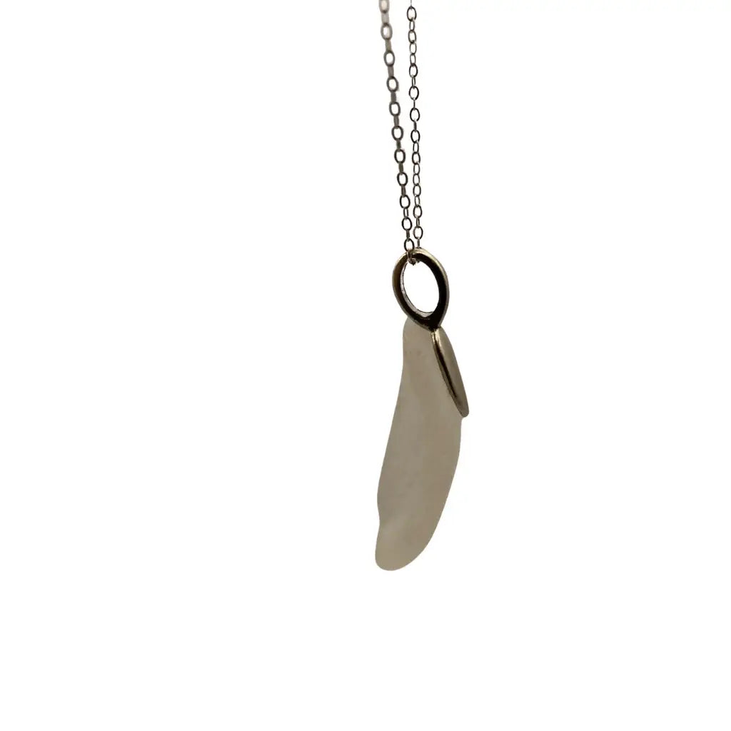 Large clear beach glass pendant with a smooth off-white sea glass and silver chain inspired by prairie history