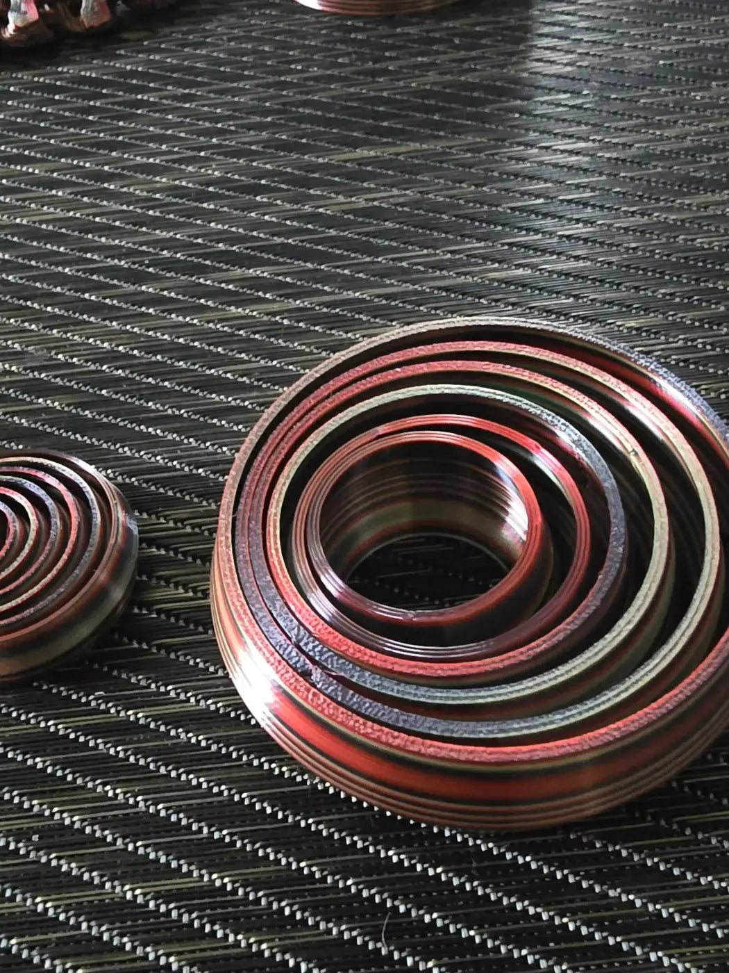 Large spinner showing red and metallic circular mechanical seals arranged in concentric rings on a textured surface for handmade soap canada pure wash