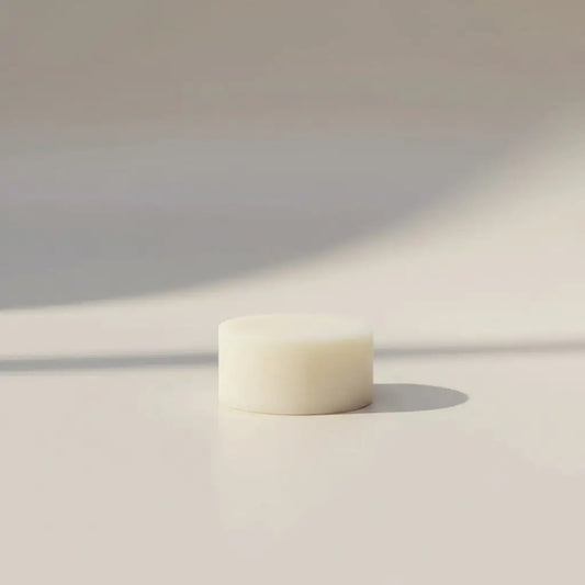 Cream-colored cylindrical conditioner bar with smooth matte finish for lavender chamomile conditioner use