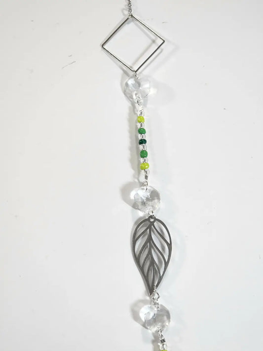Leaf 1 long suncatcher featuring a delicate silver-toned leaf with clear crystal beads and green yellow accents is an iridescent ornament and small reflective decor