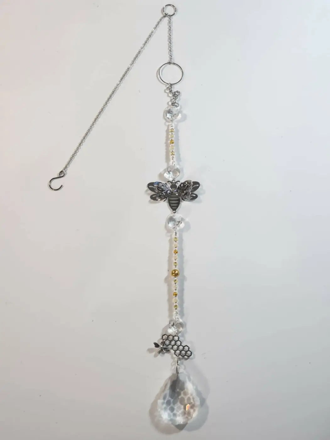 A handmade long suncatcher with clear crystal beads and a black metallic bee charm designed for direct sunlight