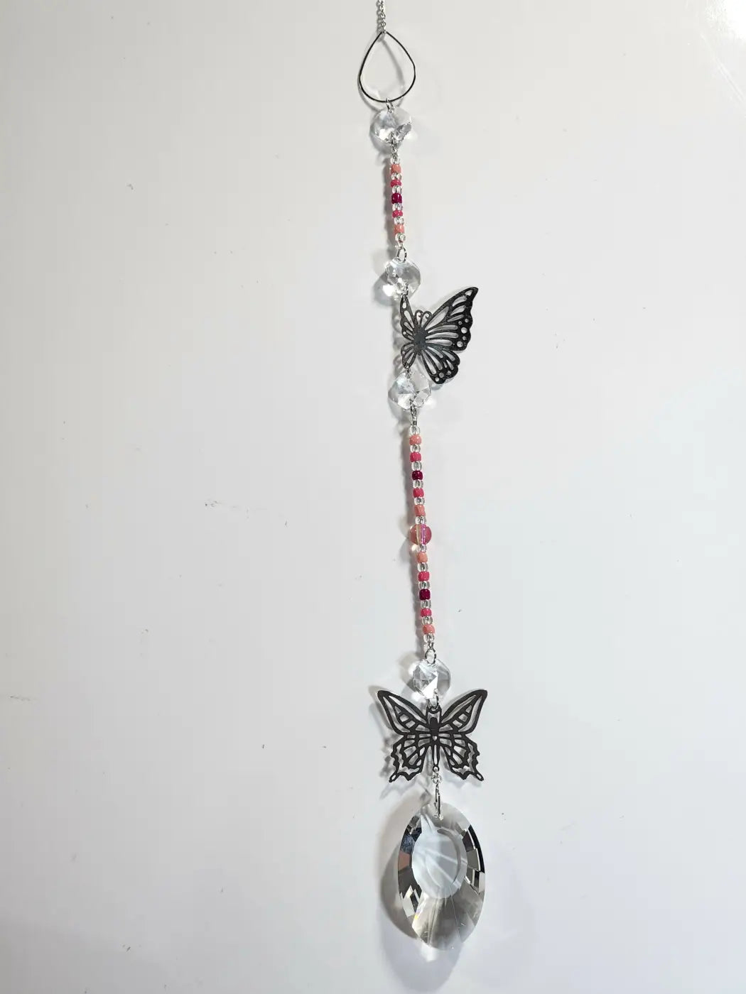 Delicate long suncatcher with black metal butterfly charms pink gemstones and crystal beads for direct sunlight display