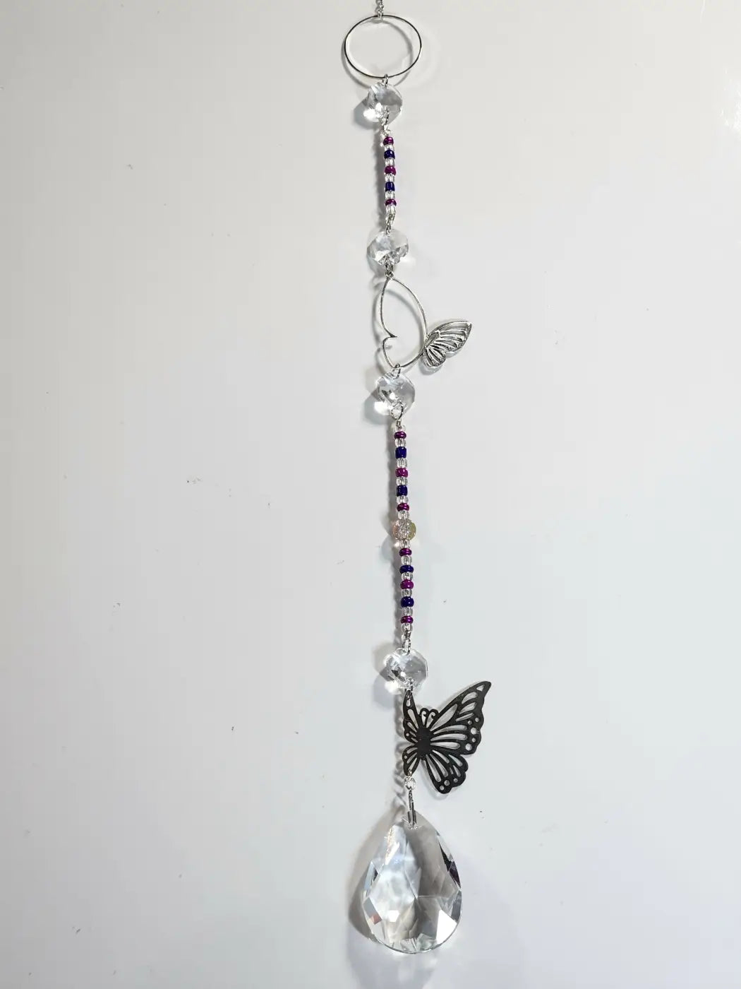 Long suncatcher with clear faceted beads purple and silver seed beads black butterfly charms and teardrop crystal for direct sunlight