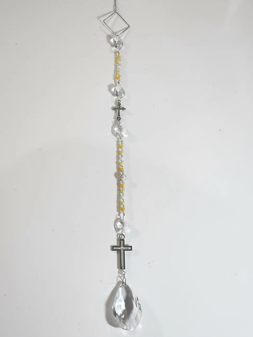Long suncatcher with silver metal frame yellow and clear beads two crosses and teardrop prism for direct sunlight decor