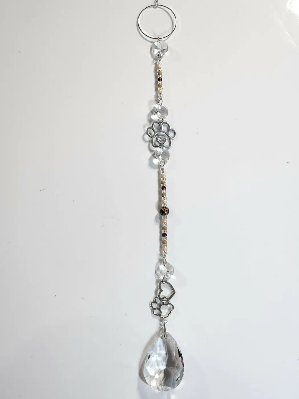 Long suncatcher with clear crystal, silver paw print charm, gold and brown beads, ideal for direct sunlight with suction cup