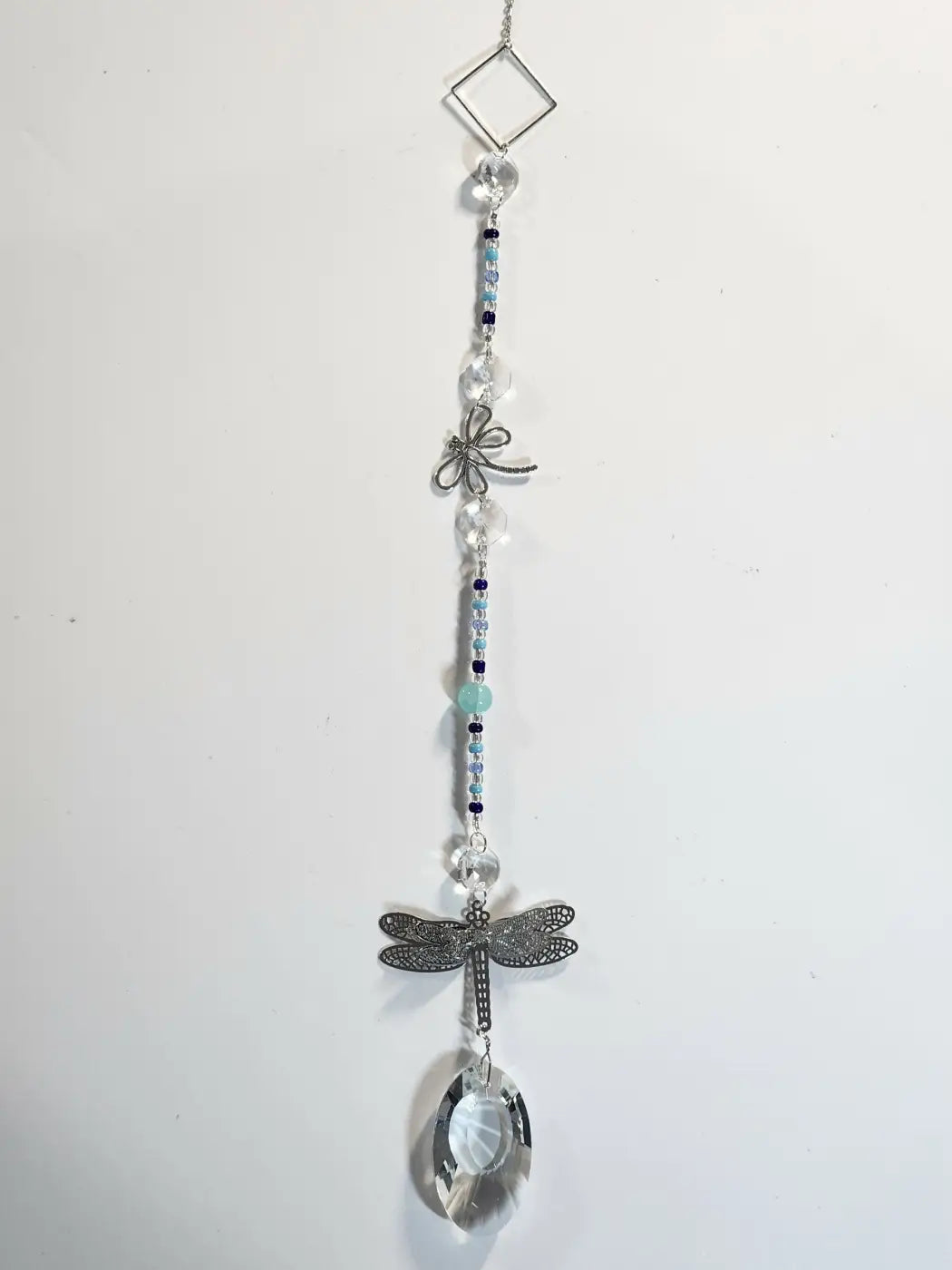 Long suncatcher featuring a delicate silver dragonfly with clear crystal beads and a faceted teardrop pendant for direct sunlight