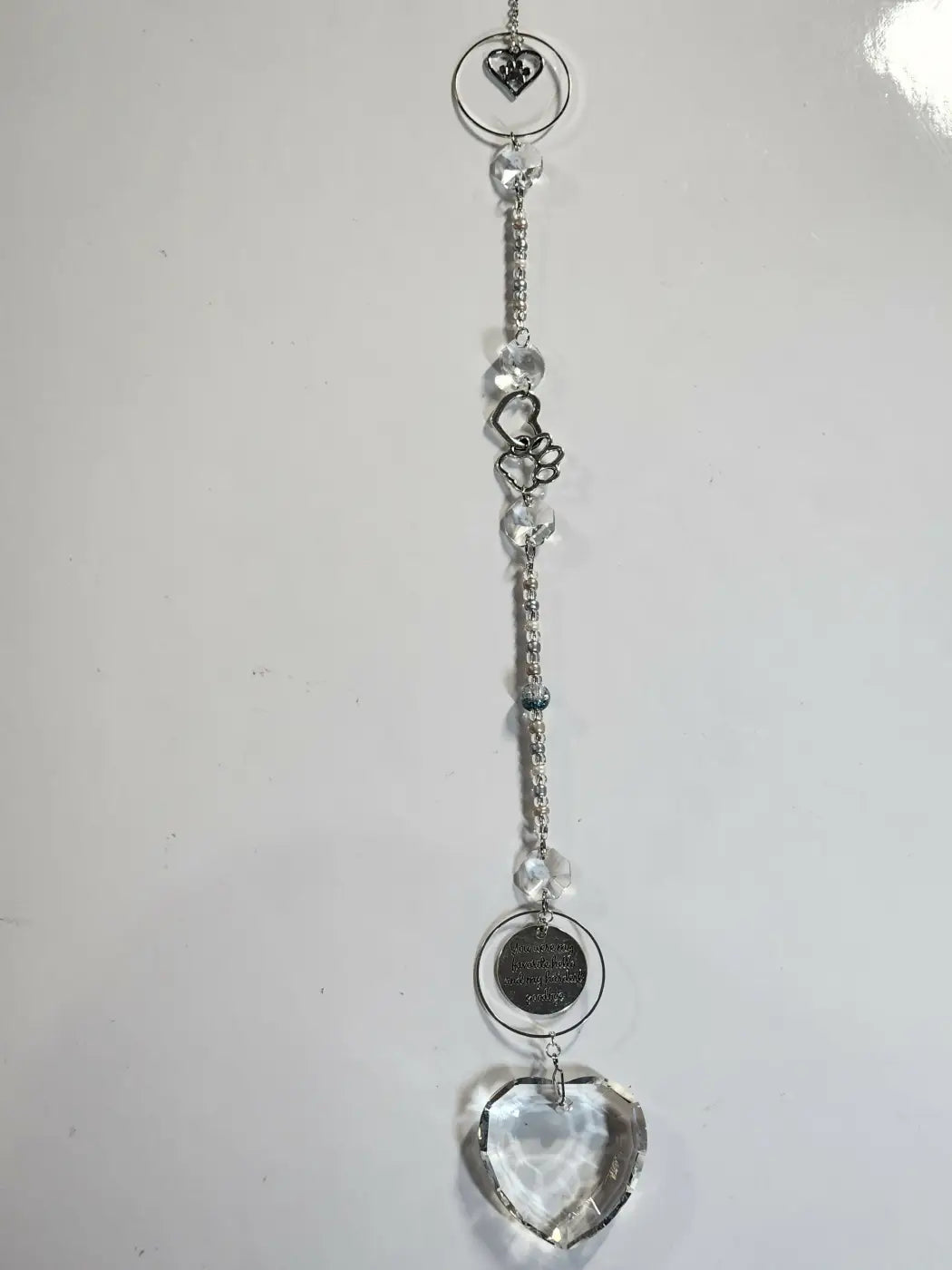 Delicate long suncatcher with silver tone, clear crystal beads, and faceted heart charm ideal for direct sunlight display
