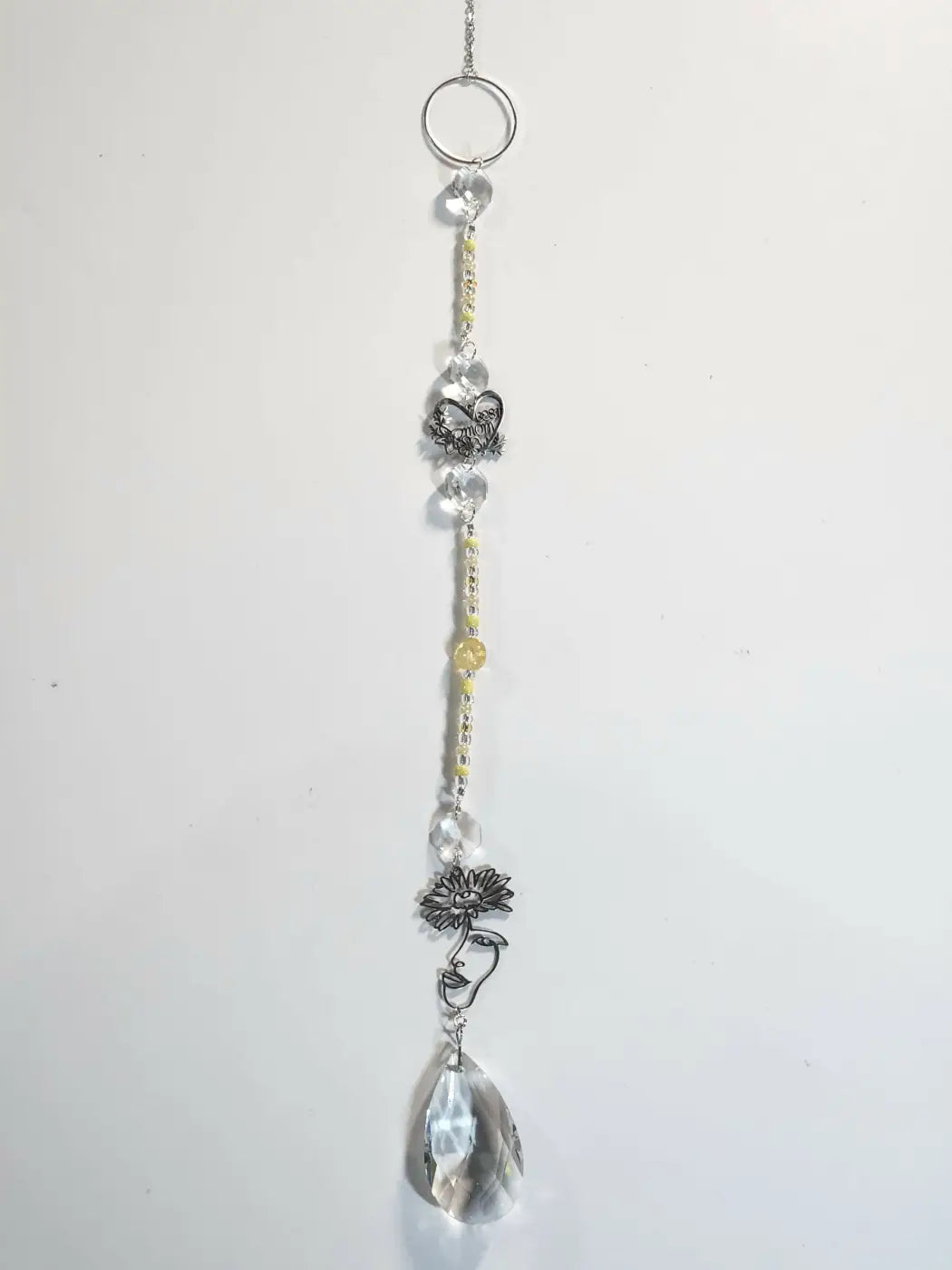 Long suncatcher with silver tones, clear and yellow beads, butterfly charm, and teardrop crystal for direct sunlight display