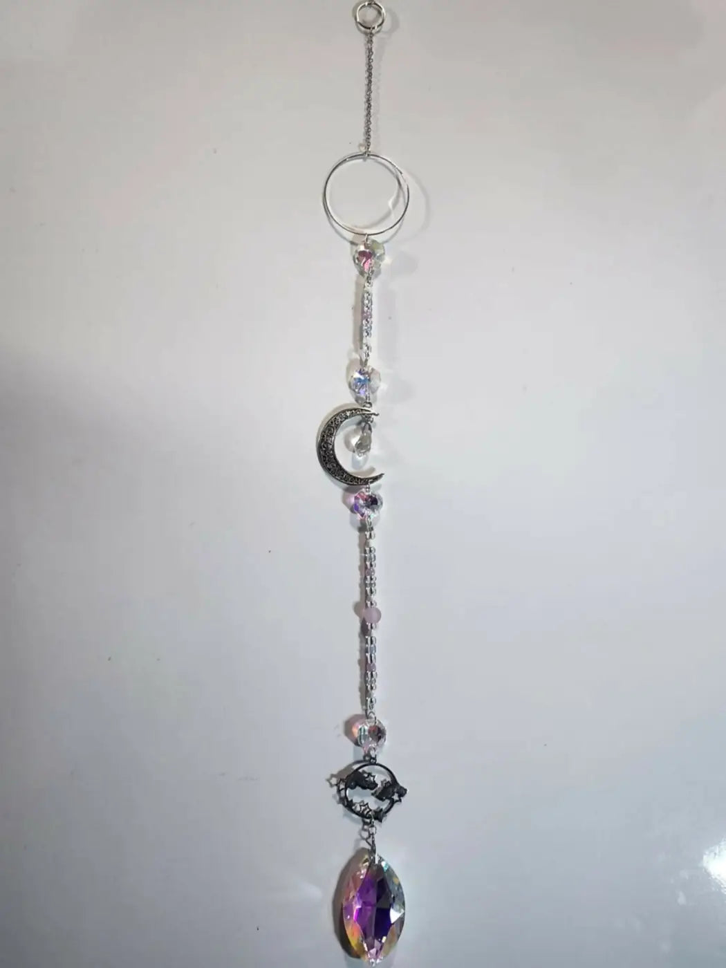 Long suncatcher with silver crescent moon, black dragon pendant, and iridescent crystals for direct sunlight display