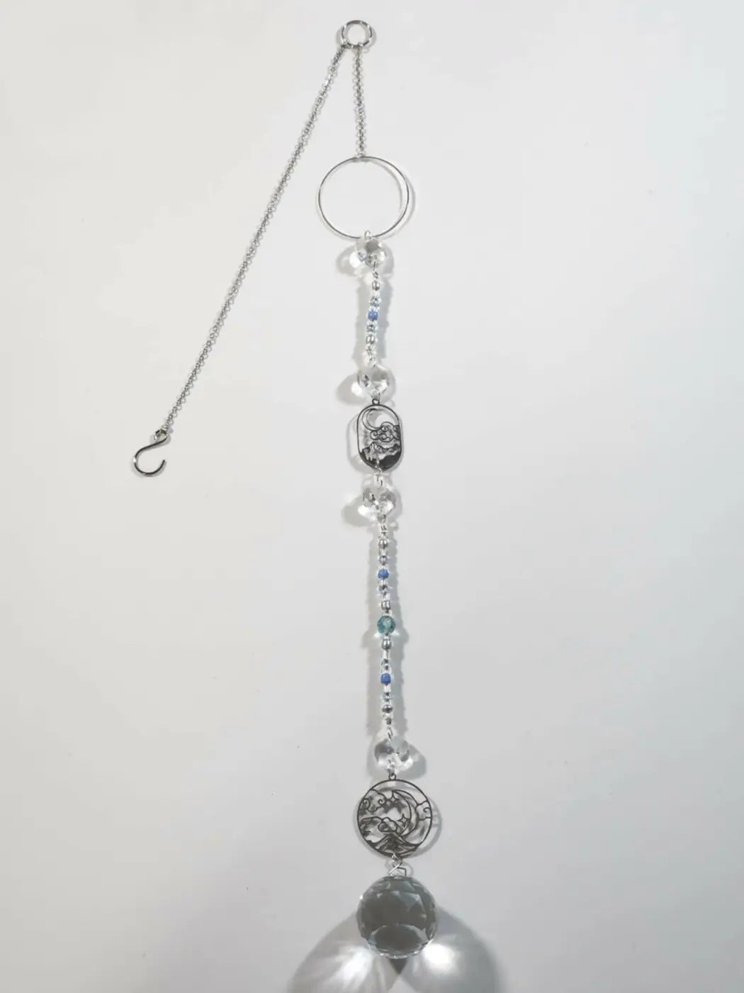 Silver-toned long suncatcher with clear and blue crystal beads featuring a skull medallion ideal for direct sunlight