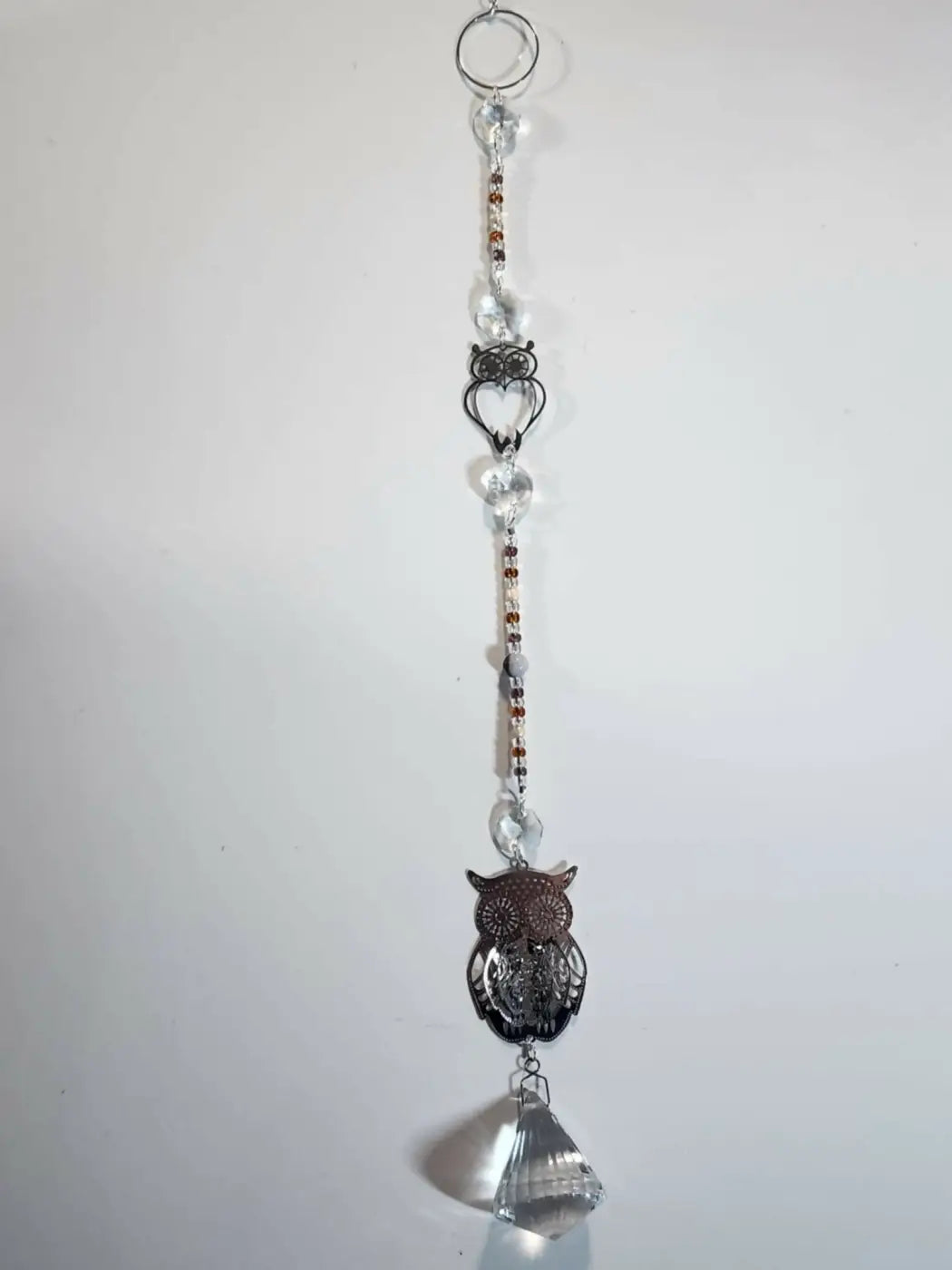 Long suncatcher featuring a dark metallic owl with clear and amber beads and faceted crystal for direct sunlight display