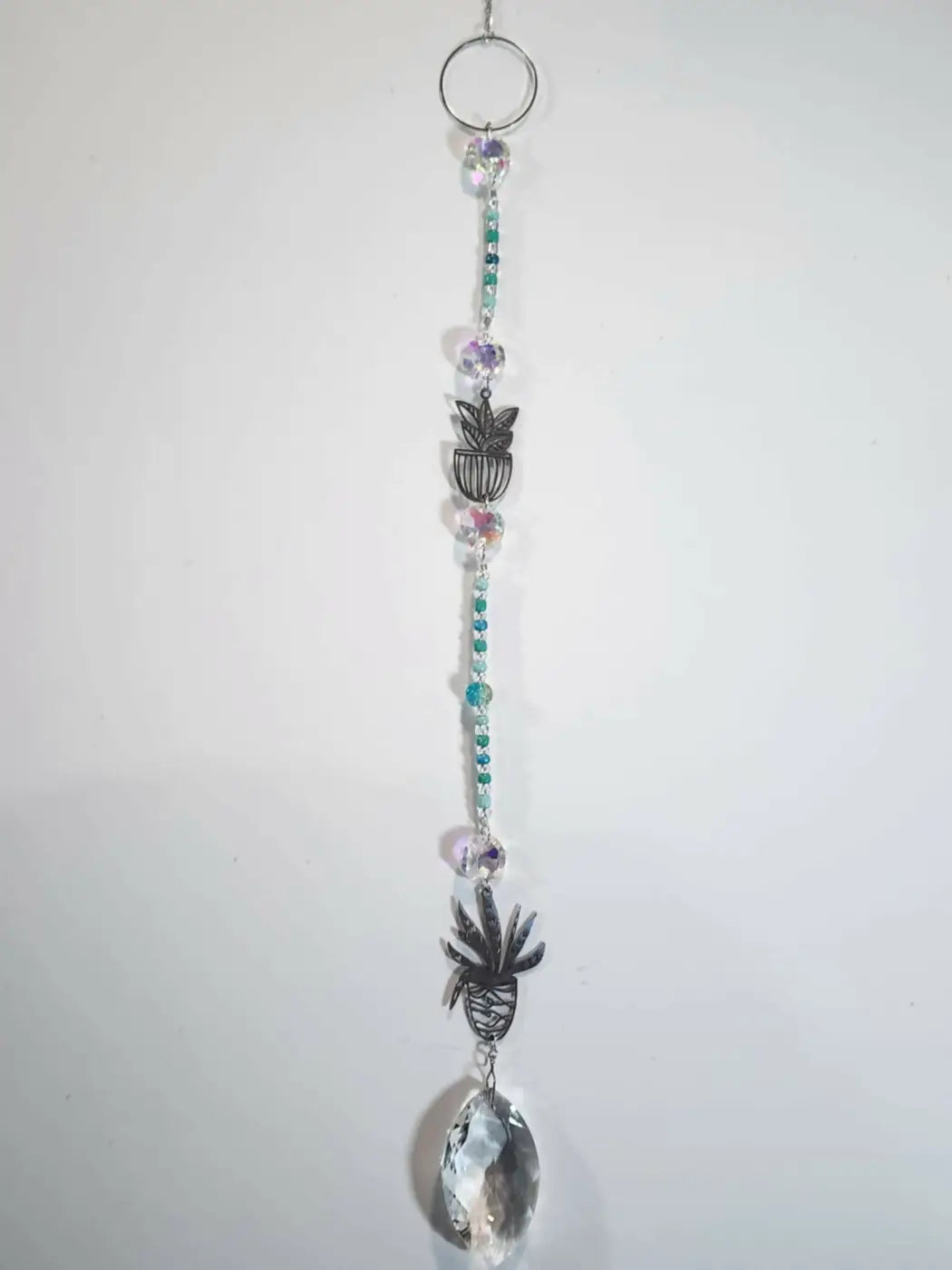 Long suncatcher with silver metal ring, teal and clear beads, pineapple charms, and faceted crystal teardrop for direct sunlight