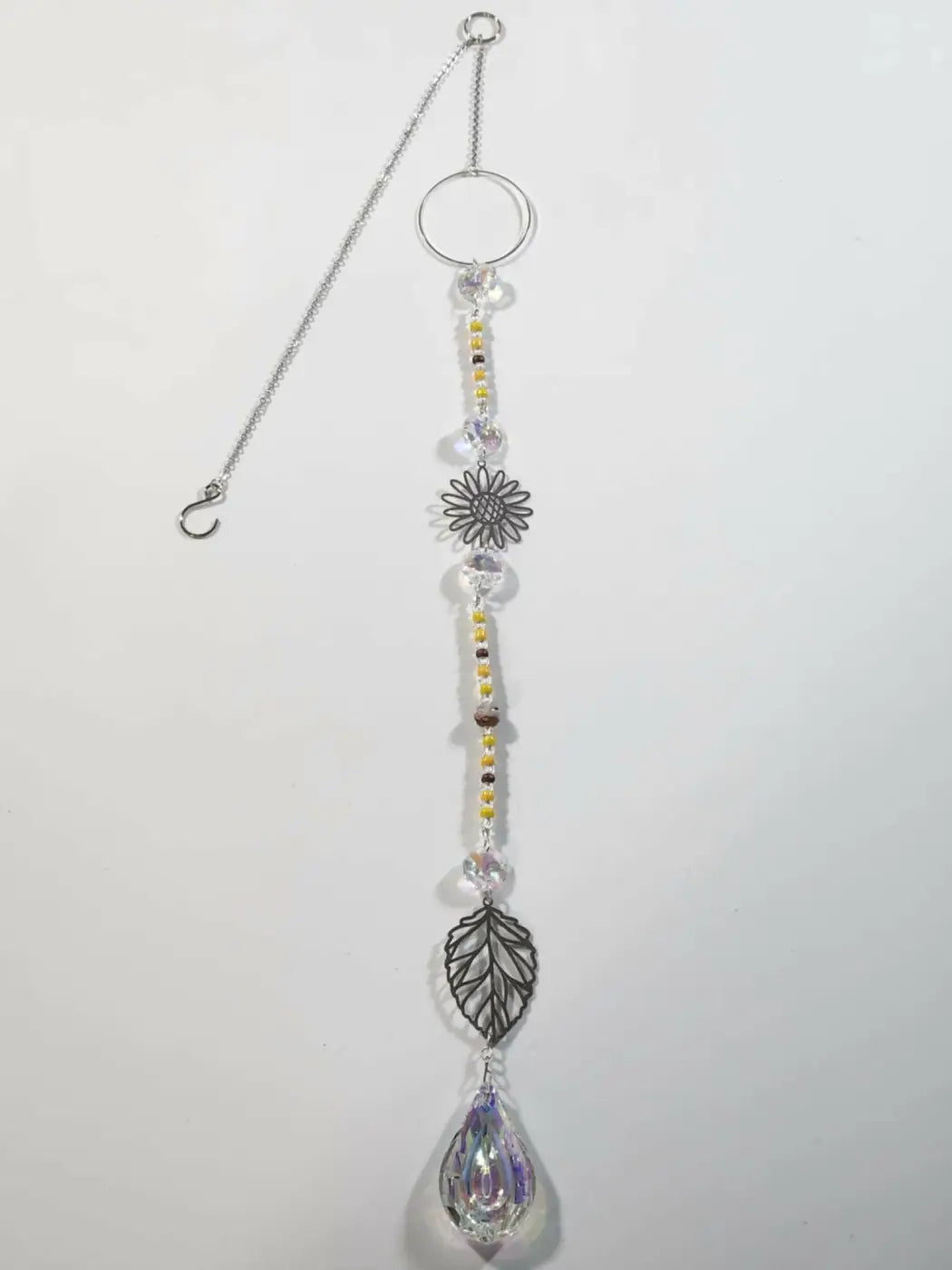 Silver-toned long suncatcher pendant with sunflower leaf design clear crystal beads and yellow accents for direct sunlight display