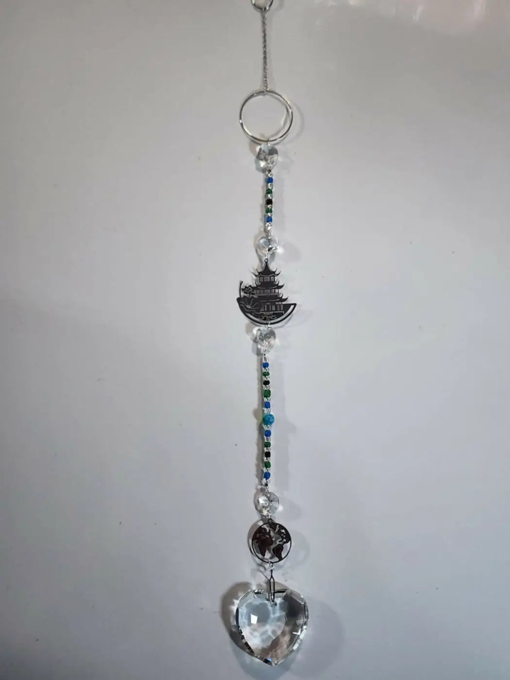 Long suncatcher with a delicate silver-toned tiered pagoda charm and clear crystal heart for direct sunlight display