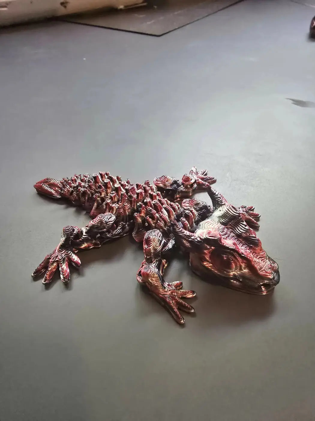 Mini dragon figurine with metallic red and silver finish featuring textured details as the smallest dragon collectible