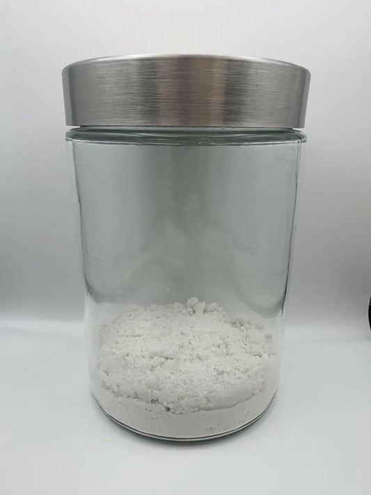 Mint Toothpaste Powder by Prairie Made Co. in a clear glass jar with a brushed stainless steel lid