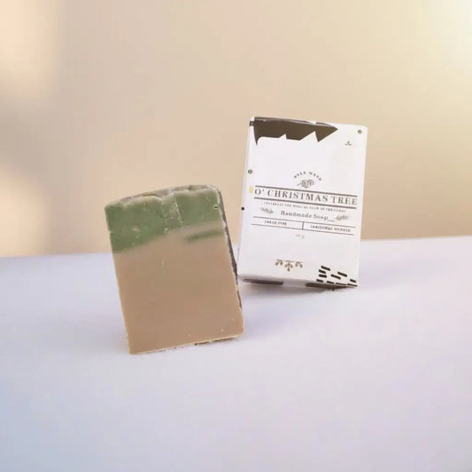 A rectangular two-toned handmade christmas tree bar soap with a green top and beige bottom for fresh pine christmas scents