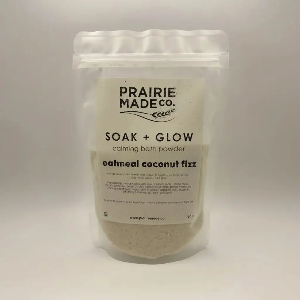 A clear resealable pouch of Prairie Made Co soak + glow calming bath oatmeal coconut fizz sprinkle with white label