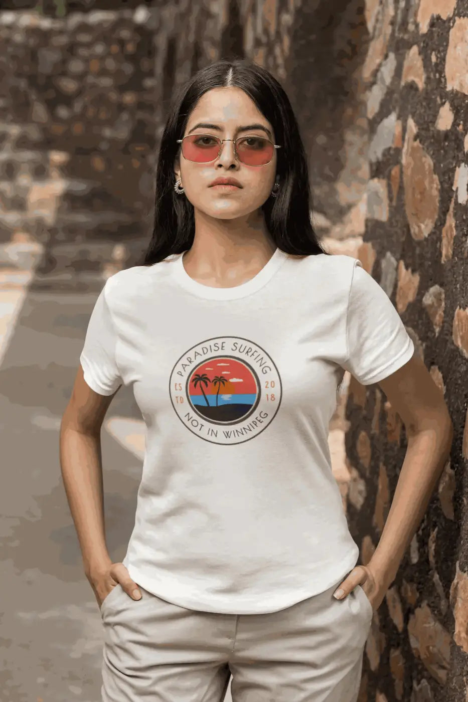 White cotton t-shirt featuring a palm tree sunset graphic and paradise surfing not in winnipeg text novelty beach t shirt funny quote
