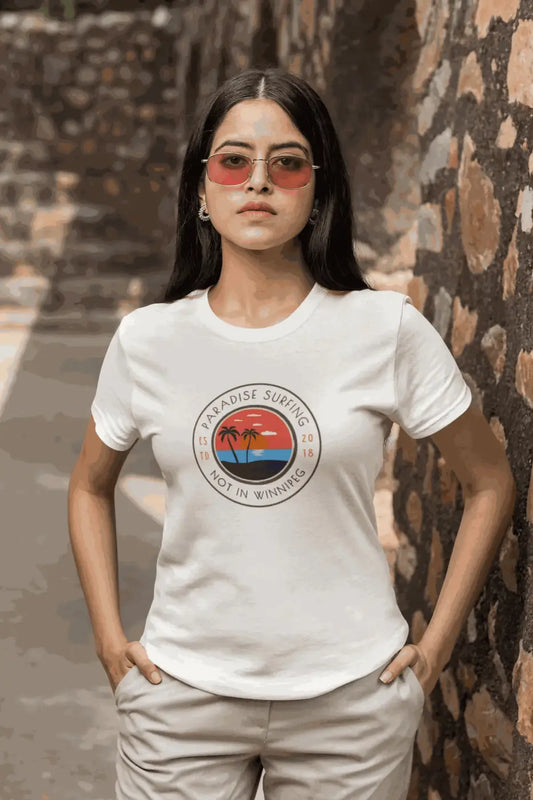 White cotton t-shirt featuring a palm tree sunset graphic and paradise surfing not in winnipeg text novelty beach t shirt funny quote