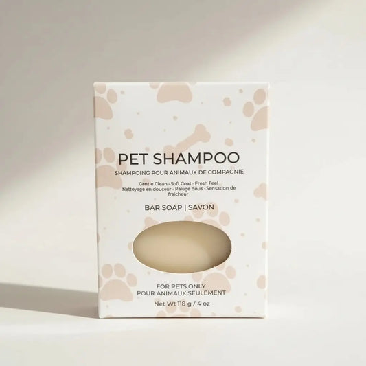 A creamy beige neem pet shampoo bar in a white box with pink paw prints for a low-waste grooming routine and shiny coat