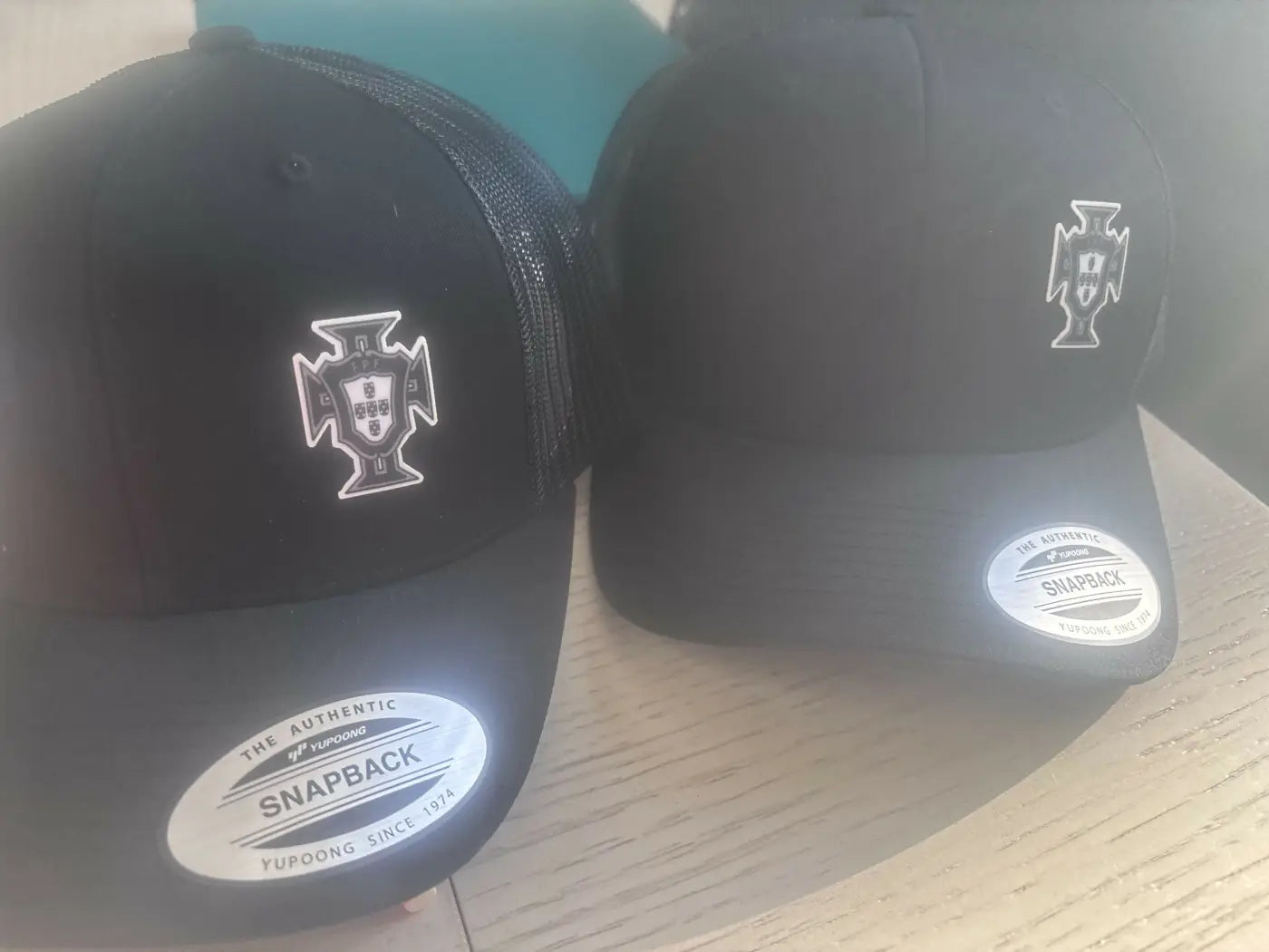 Black snapback portugal hat with white embroidered portuguese crest and the authentic snapback label for casual wear
