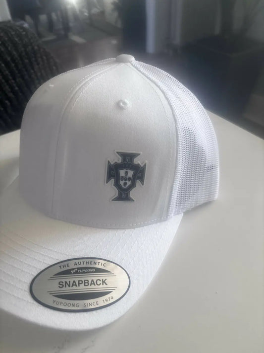 White portugal hat with black embroidered crest, mesh back, and authentic yupoong oval label, ideal for natural skincare canada fans