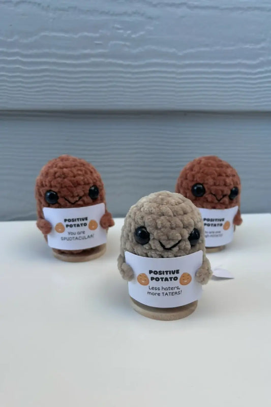 Crocheted positive potato figurines with black button eyes and white paper labels for natural skincare canada