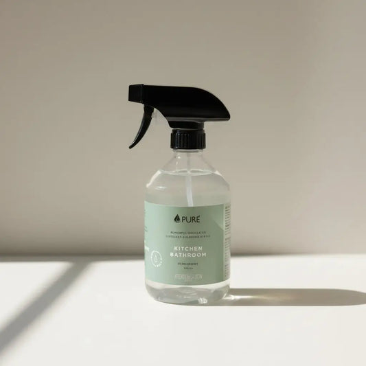 Clear glass spray bottle with black trigger labeled pure kitchen bathroom for instore refill and acid synthetic cleaning