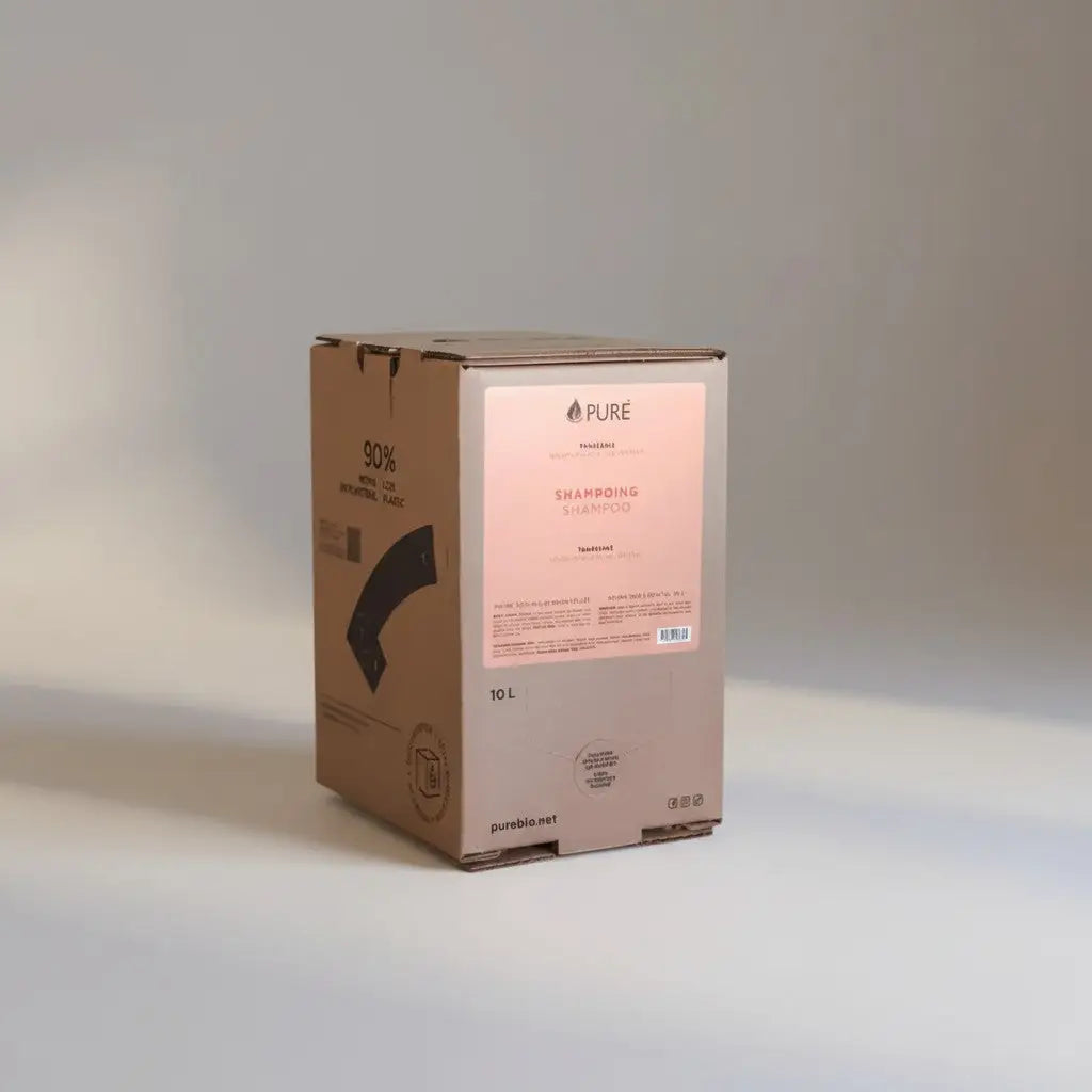A 10-liter cardboard box of pure shampoo tangerine with a minimalist pink label featuring plant derived cleaning for in-store refill