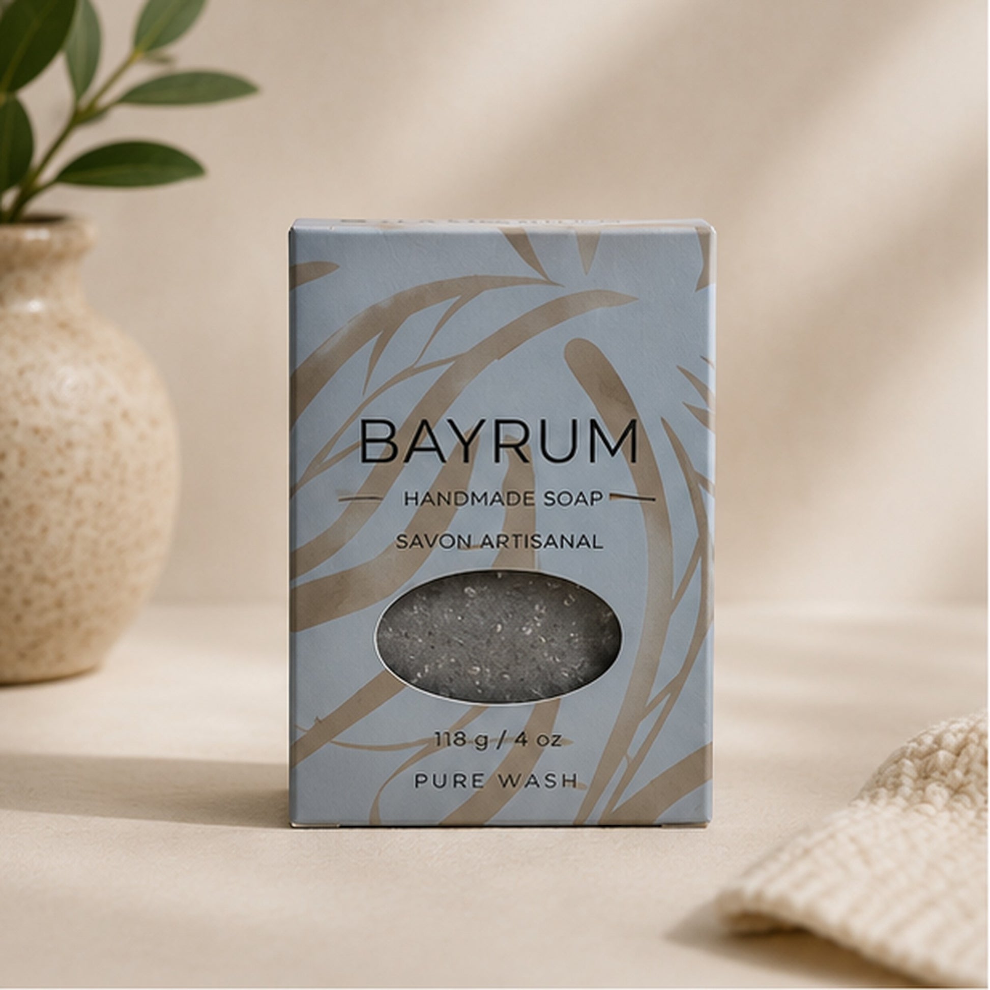 Pure Wash Bay Rum handmade soap bar in a light blue box with palm leaf print, featuring a cutout window.