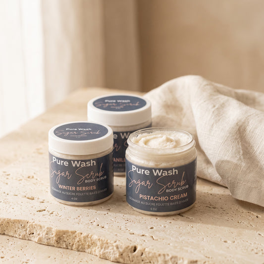 Pure Wash body sugar scrubs in Pistachio Cream and Winter Berries scents on a textured stone surface with a cloth.