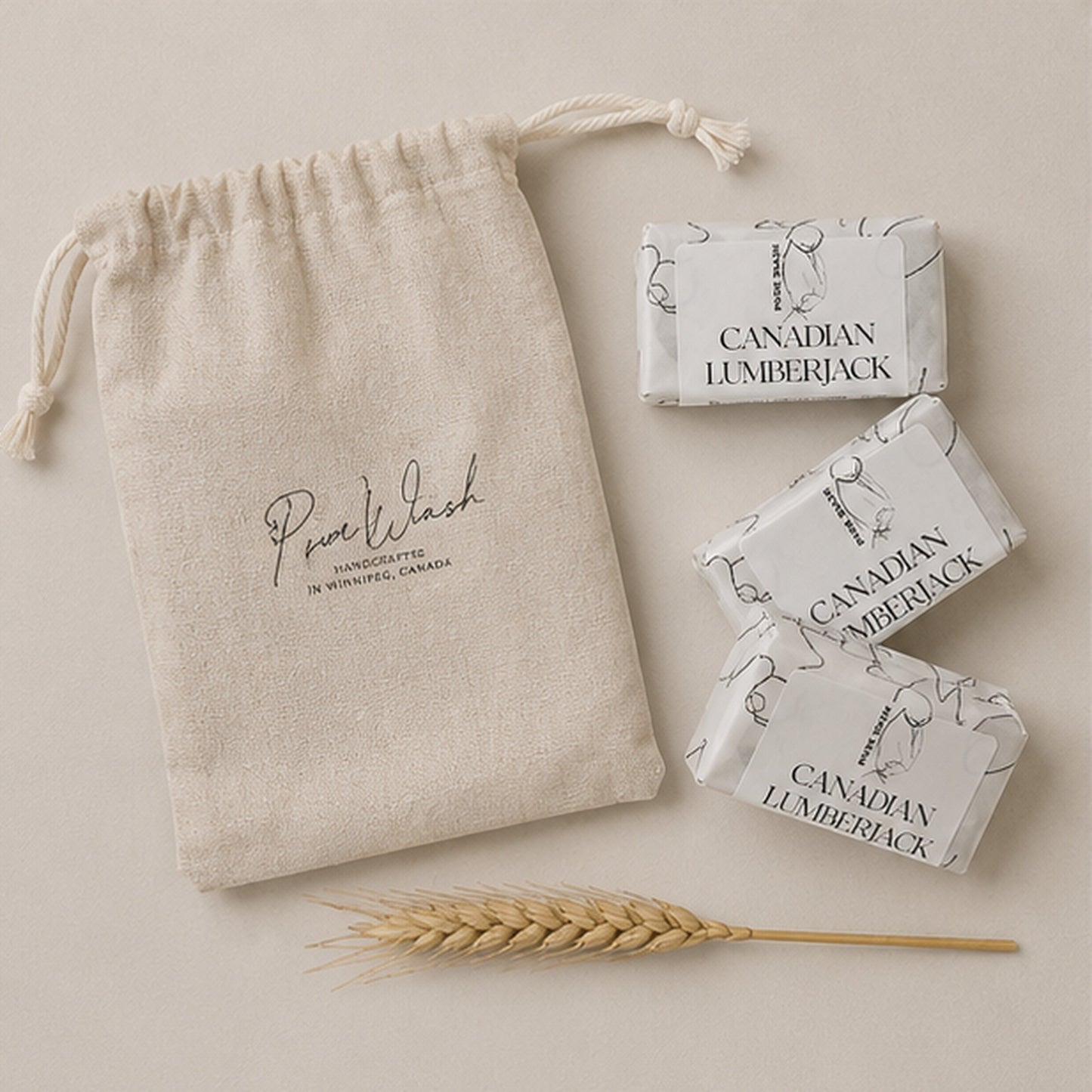 Pure Wash botanical soap trio with three handmade bars in a beige cotton canvas drawstring bag on a neutral background.