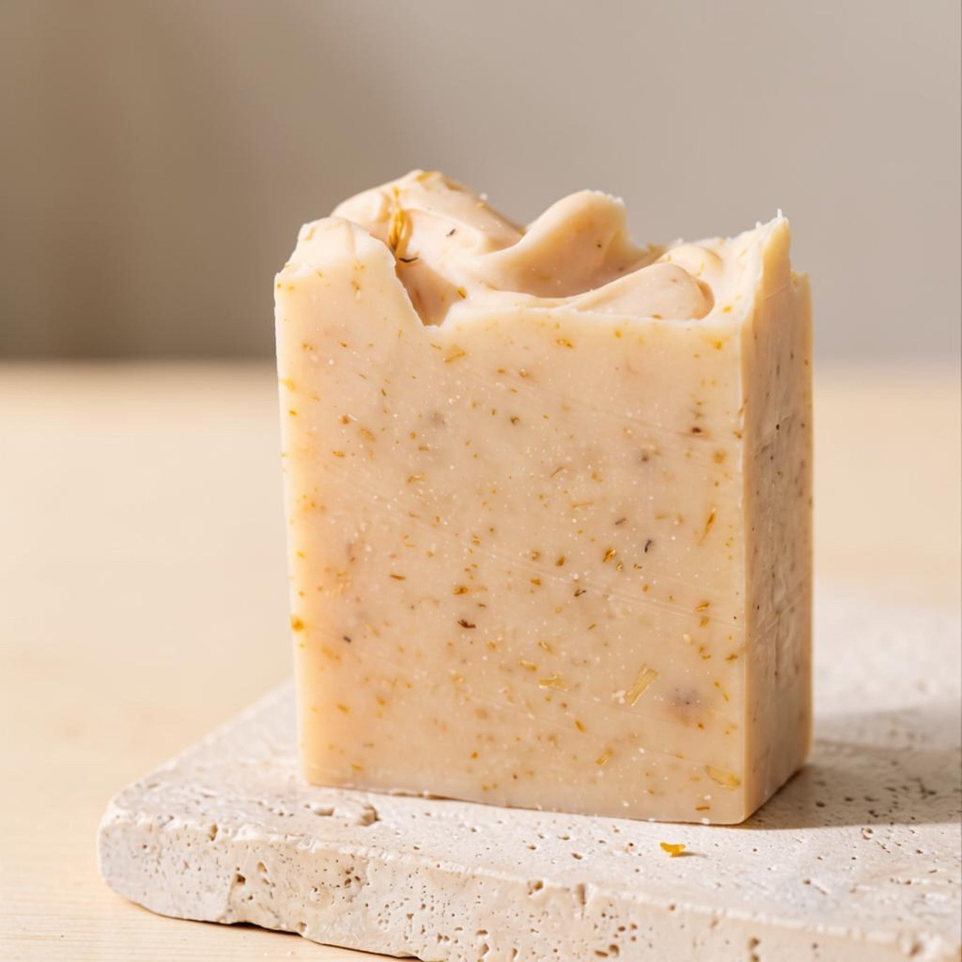 Pure Wash fragrance-free calendula soap bar with rustic dried petals for sensitive skin on a textured stone base