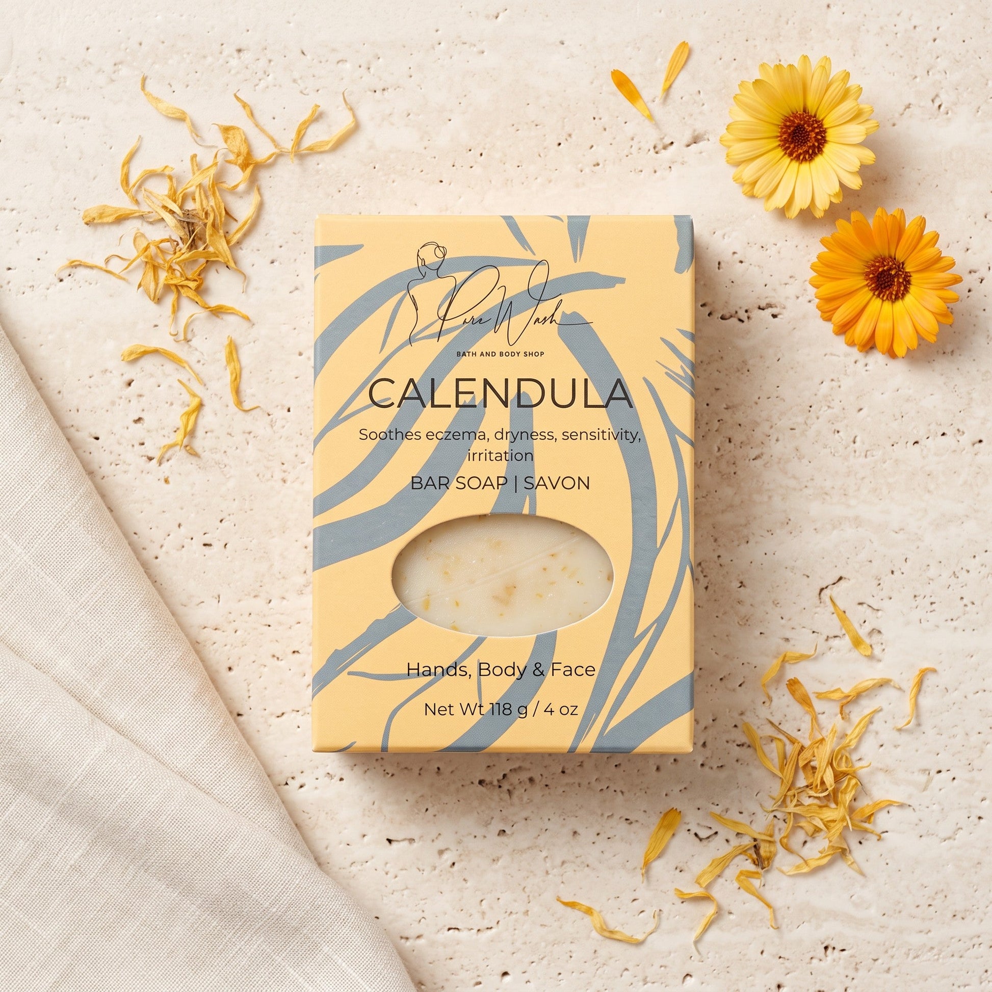 Pure Wash Calendula soap bar in yellow patterned packaging with dried flower petals on a textured stone surface.