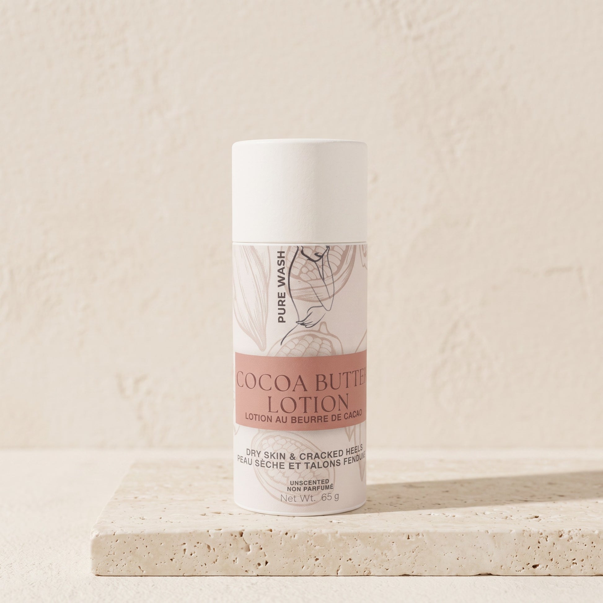 Pure Wash cocoa butter lotion bar in a white tube for dry skin, displayed on a textured stone surface.