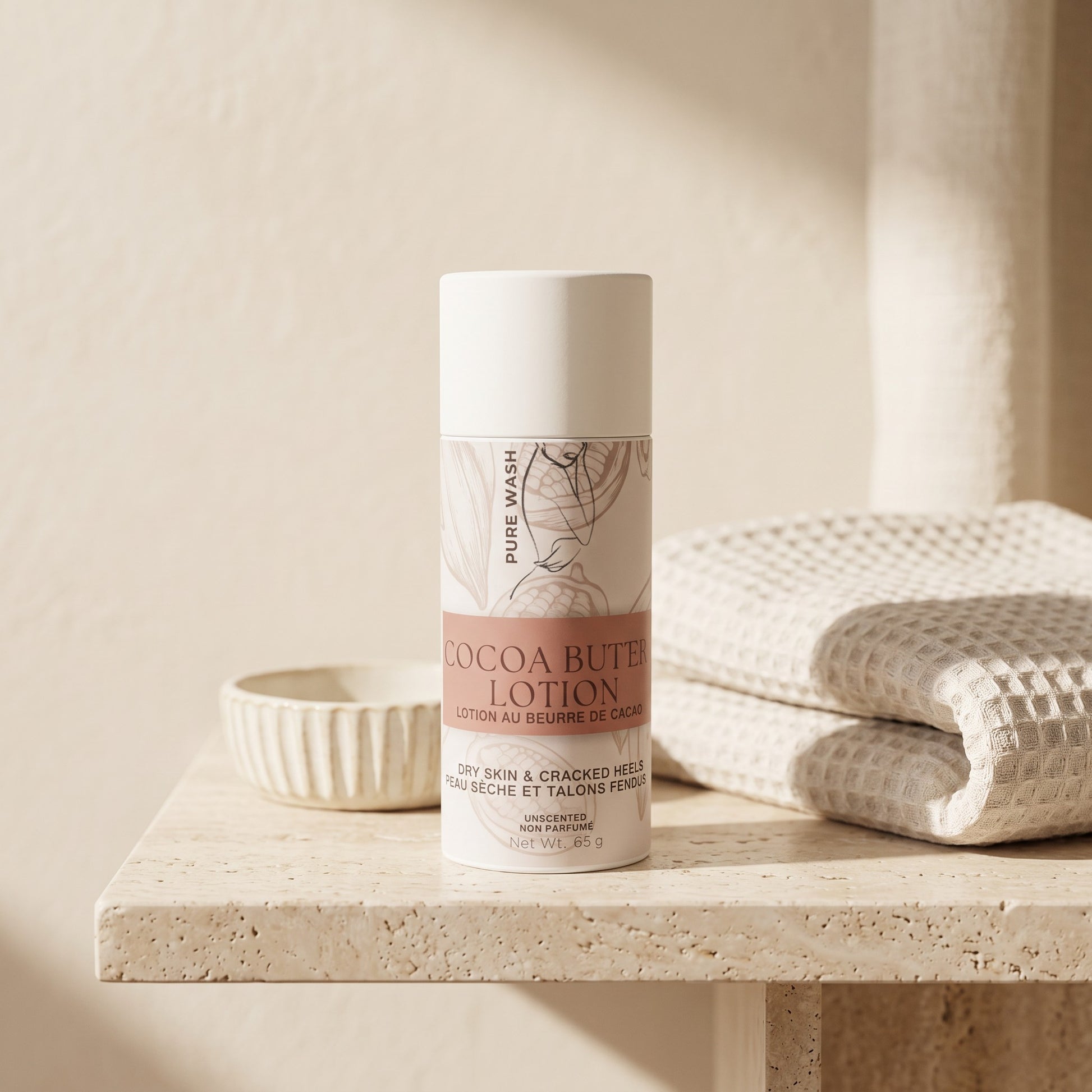 Pure Wash cocoa butter lotion stick in a white tube on a stone surface with folded towels for dry skin care.
