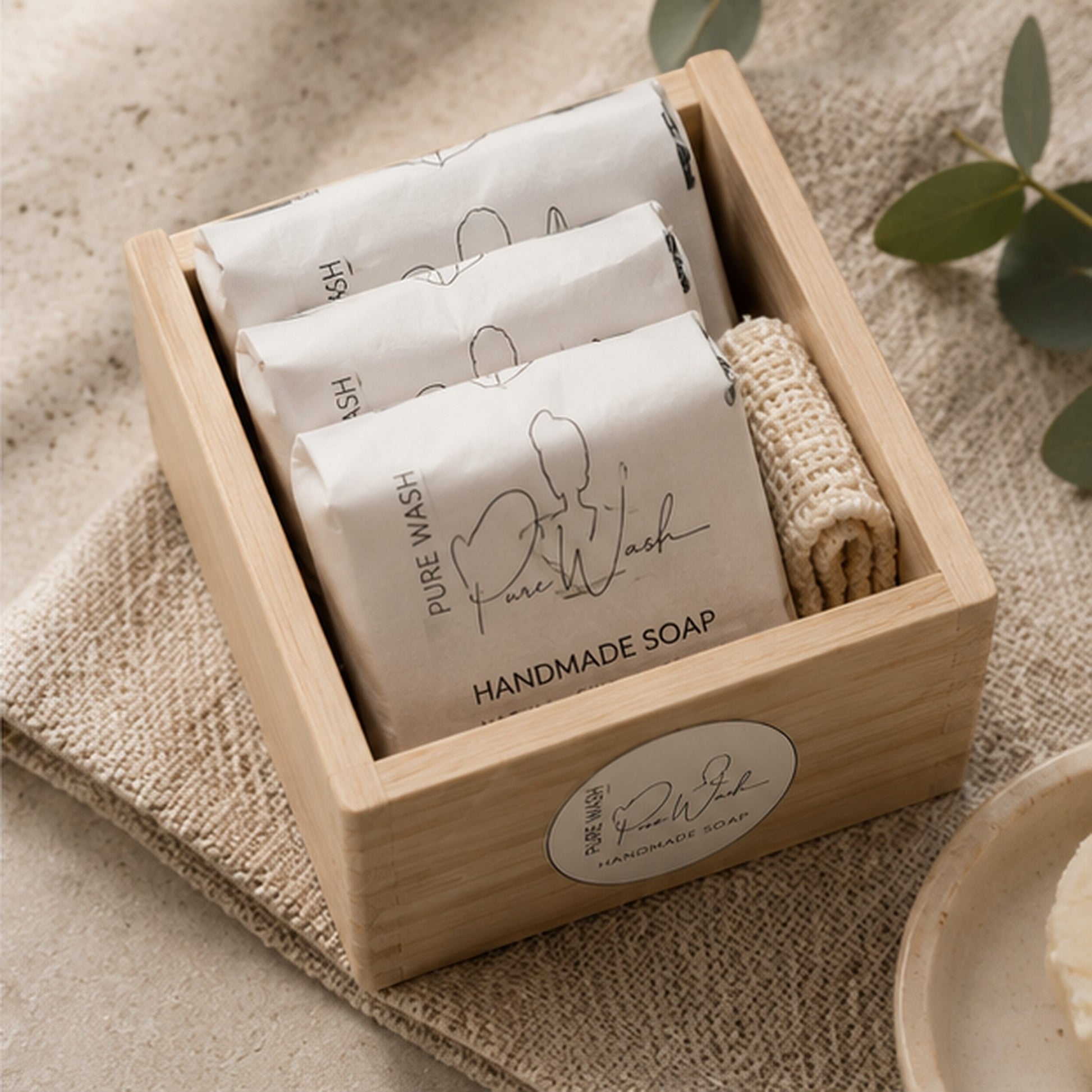 Pure Wash natural handmade soap gift set with three wrapped bars and an exfoliating bag in a wooden storage box.