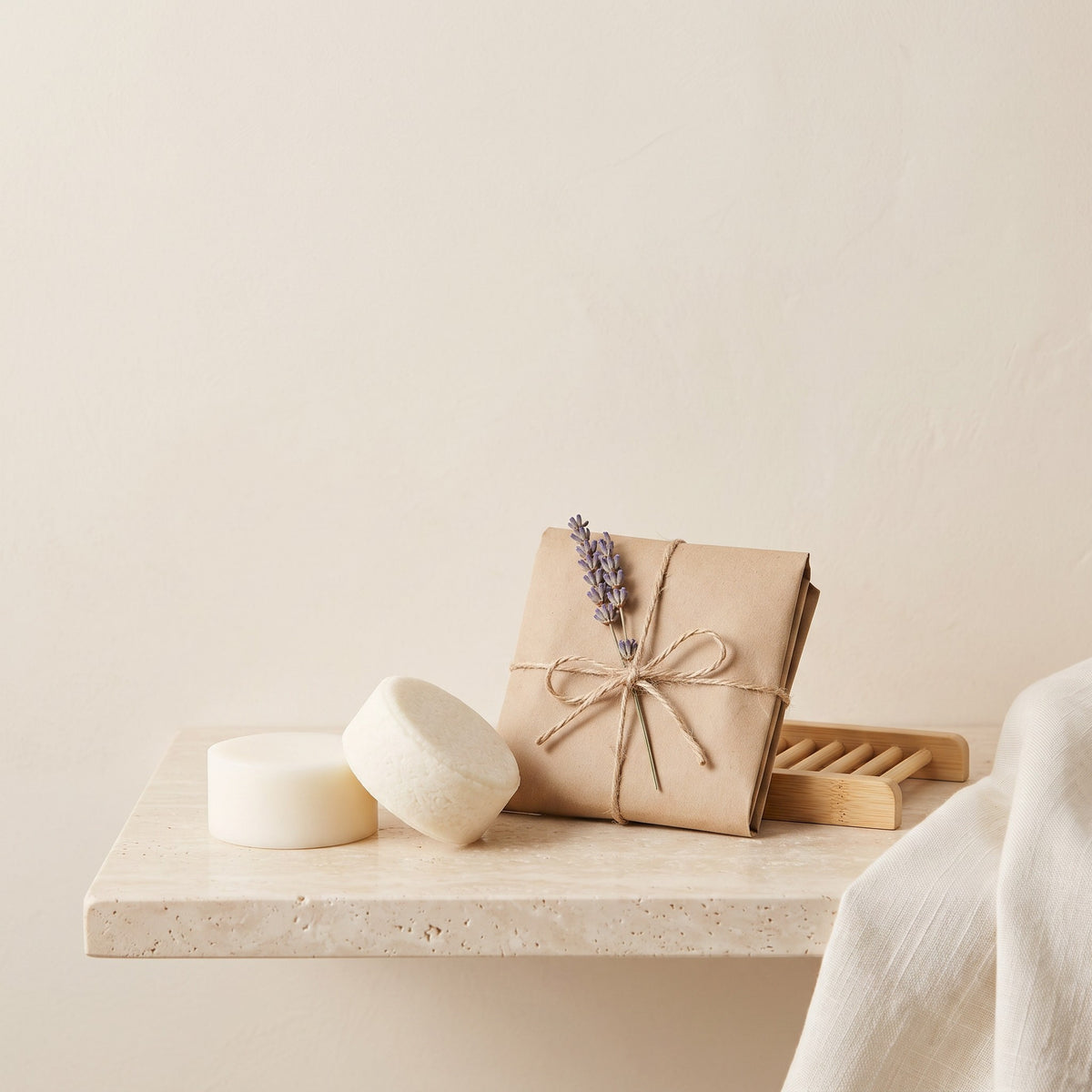 Pure Wash Lavender Chamomile conditioner bars with shea butter, wrapped in paper with a lavender sprig on a shelf.