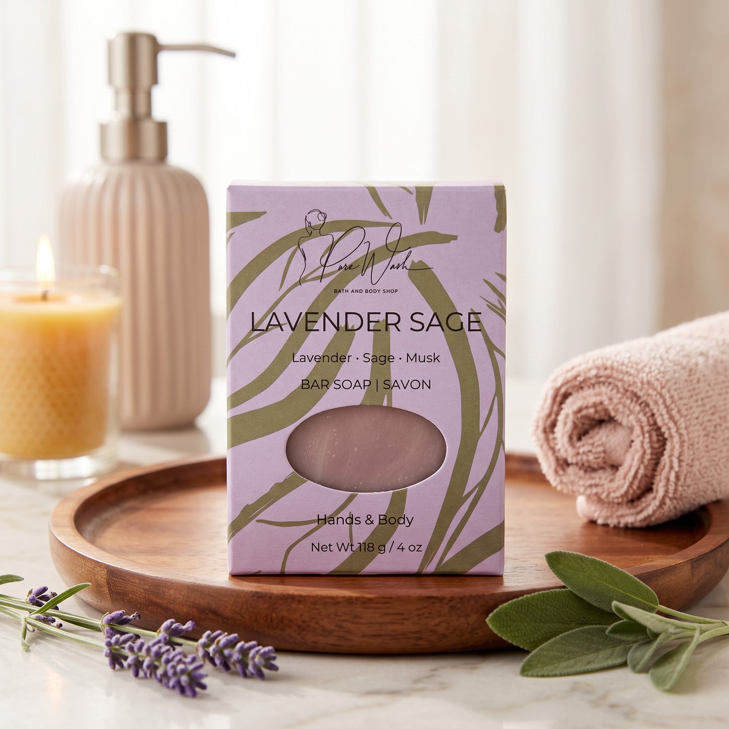 Pure Wash Lavender Sage soap bar in purple packaging on a wooden tray with a candle, towel, and fresh herbs.